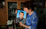 Galina Inkina tient un portrait de son fils Denis Inkine, mineur chez ArcelorMittal tué dans un accident en novembre 2022, chez elle à Chakhtinsk, dans le centre du Kazakhstan le 8 septembre 2023