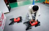 Un ingénieur contrôle un robochien baptisé AlphaDog dans l'atelier de l'entreprise Weilan à Nankin, le 2 avril 2021