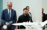 Le chancelier allemand Friedrich Merz (g) et le président ukrainien Volodymyr Zelensky (d) assistent à une présentation de drones issus de la coopération germano-ukrainienne, le 14 avril 2026 à Berlin