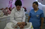 La commerçante Alana Generoso (g) donne le bain à un "bébé reborn" dans sa boutique Maternité Alana Babys à Campinas, dans l'État de Sao Paulo, au Brésil, le 16 mai 2025