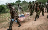 Des agents de sécurité kényans transportent une personne dans la forêt de Shakahola, où des corps ont été exhumés près de la ville côtière de Malindi (est), le 23 avril 2023