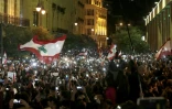 Des manifestants libanais utilisent les lumières de leurs téléphones portables, le 15 décembre 2019 dans le centre-ville de Beyrouth