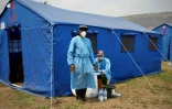 Sous des tentes, les équipes de dépistage contrôlent la température des passagers et vérifient l’absence de symptômes d'Ebola, au port fluvial de Bende-Bende, commune de Maluku, en République démocratique du Congo (RDC), le 20 août 2026