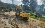 Photo prise et diffusée le 26 mai 2024 par l'Organisation internationale pour les migrations d'une pelleteuse se dirigeant vers le site d'un glissement de terrain au village de Yambali, dans la province d'Enga en Papouasie-Nouvelle-Guinée
