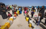 Des déplacés palestiniens attendent pour obtenir de l'eau à Deir el-Balah, dans la bande de Gaza, en Territoires palestiniens, le 21 mai 2024