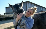 Stéphanie Lisicki câline un cheval handicapé au refuge et centre de soins Suzi Handicap à Montreuil-au-Houlme, le 18 mars 2025 dans l'Orne