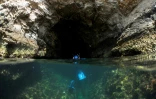 Un biologiste marin entre dans une grotte où viennent se reposer et se reproduire des phoques moines, les mammifères les plus en danger de Méditerranée. Photo prise le 23 mai 2018