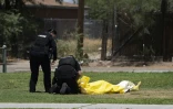 Des policiers s'occupent du corps sans vie d'un SDF probablement mort d'hyperthermie dans le parc Estevan alors que la canicule s'abat sur Tucson, en Arizona, le 15 juillet 2023