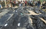 Des Irakiens se recueillent près de corps de personnes qui auraient été tuées par le groupe Etat islamique, dans la ville de Tikrit, le 12 avril 2015