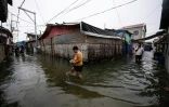 Des habitants dans une rue inondée de l'île de Pugad, dans la province de Bucalan, le 21 août 2025 aux Philippines