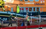 Des ambulanciers portent secours à un migrant récupéré en mer alors qu'il tentait de traverser la Manche à Douvres, dans le sud-est de l'Angleterre, le 12 août 2023