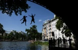 Des jeunes sautent d'un pont dans le canal Saint-Martin lors d'une vague de chaleur à Paris, le 22 juin 2026