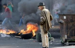 Un Libanais observe des pneus brûler lors d'une manifestation contre le gouvernement à Beyrouth, le 18 octobre 2019