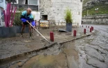 Un homme nettoie la boue sur un trottoir à Anduze, le 19 septembre 2020