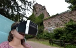 Une femme porte un casque vidéo sur les yeux et visite virtuellement le château de Kintzheim grâce à la diffusion d'images haute définition tournées par un drone, le 21 juin 2016
