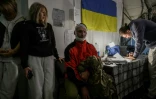 Un soldat ukrainien (C) blessé par un drone attend d'être soigné dans un centre de stabilisation, près de la ligne de front dans la région de Donetsk, dans l'est de l'Ukraine, le 10 octobre 2025 