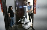 Un ingénieur de X Square emmène un robot après qu'il a effectué des tâches ménagères au domicile d'une cliente , le 21 mai 2026 à Pékin, en Chine