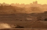Une photo prise depuis une position à la frontière israélienne avec la bande de Gaza, montre des troupes israéliennes se déployant près du territoire palestinien, le 19 août 2025
