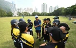 Des domestiques philippines, membres de l'équipe des SCC Divas, écoutent leur coach Sher Lama (c) avant un match de cricket, le 8 novembre 2020 à Hong Kong