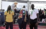 Le président du Sénégal Macky Sall avec le trophée de la CAN, entouré du sélectionneur Aliou Cissé (g) et du capitaine Kalidou Koulibaly, le 7 février 2022 à Dakar
