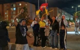 Des manifestants brandissent des drapeaux et tiennent des pierres lors d'affrontements liés aux résultats préliminaires du second tour de l'élection présidentielle à Bogota, en Colombie, le 21 juin 2026