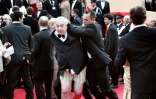 Le comique et entarteur belge Noël Godin est évacué du tapis rouge du Palais des Festivals par le service de sécurité, le 15 mai 2004, juste avant l'arrivée des célébrités pour la projection officielle de "Shrek 2" lors du Festival de Cannes