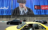 Des automobilistes passent devant un panneau géant sur lequel figure une photo de l'ayatollah Ali Khamenei, le défunt guide suprême de l'Iran, le 2 juillet 2026 à Téhéran, à la veille de ses funérailles