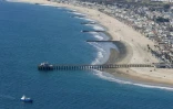 Le ponton de Huntington Beach, en Californie, et sa plage où des équipes de nettoyage s'affairent à dépolluer après une fuite de pétrole brut sur un oléoduc voisin, vus depuis un avion des gardes-côtes le 6 octobre 2021