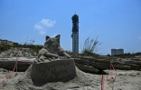 Une sculpture de sable représentant un chat jouant du piano et les mots "Suspenseful Music" est visible devant la fusée Starship à la base spatiale Starbase de SpaceX à Boca Chica, au Texas, le 5 juin 2024