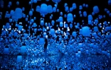 Une membre du collectif japonais teamLab se promène dans un entrelacs de lampes, le 1er mai 2018 au Mori Building Digital Art Museum à Tokyo