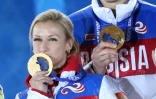 Les Russes Tatiana Volosozhar et Maxim Trankov sur le podium des Jeux olympiques de Sotchi le 13 février 2014 avec leur médaille d'or remportée en couple