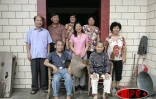 Charline Allane, née Cheung-Chun-Wah (au centre avec le chapeau dans les mains) devant la maison de ses ancêtres à Meixian