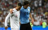 L'attaquant uruguayen Edinson Cavani (g), blessé, quitte le terrain soutenu par le Portugais Cristiano Ronaldo en 8e de finale du Mondial, le 30 juin 2018 à Sotchi