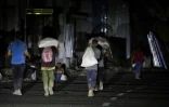 Des Palestiniens reviennent d'un point de distribution d'aide alimentaire mis en place par la Fondation humanitaire de Gaza (GHF) sur la route de Salaheddin, au camp de réfugiés de Nousseirat, dans le centre de la bande de Gaza, le 24 juin 2025