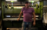 Le carrossier Pedro Manso devant une machine qu'il a lui-même fabriquée pour reproduire les pièces d'origine des vieilles voitures américaines, le 24 avril 2021 dans son atelier de Placetas, dans la province de Villa Clara, à Cuba