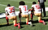 Les joueurs des Francisco 49ers Eric Reid (g) Colin Kaepernick (c) et Eli Harold genou à terre pendant l'hymne national, le 25 septembre 2016 à Seattle