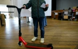 Une personne venue voter en trottinette lors d'une consultation lancée par la mairie de Paris sur l'avenir des trottinettes en libre-service, le 2 avril 2023 dans le 17e arrondissement de la capitale