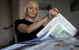 La Marocaine Yasmina Tellal, consulte des coupures de presse, dans le sud-ouest de la France, le 15 août 2025