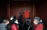 Des Chinois, un masque de protection sur le visage, devant la porte du Temple des Lamas fermé pour éviter la propagation du nouveau coronavirus, le 25 janvier 2020 à Pékin