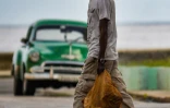 Un homme porte ses achats dans une rue de La Havane, le 3 mai 2021 à Cuba