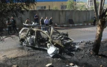 Des membres des forces de sécurité libanaises inspectent une voiture détruite par une frappe aérienne israélienne, près de la ville côtière de Damour, au sud de Beyrouth, le 22 avril 2025