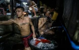 Un détenu se prépare un repas alors que d'autres se lavent dans une des cellules de la prison surpeuplée de Quezon City, près de Manille le 21 juillet 2016