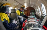 Un médecin et une infirmière prennent soin d'un patient atteint du coronavirus, enfermé dans une "capsule de protection", à bord d'un avion-ambulance à destination de Lima, le 1er septembre 2020 à l'aéroport d'Iquitos, au Pérou