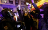 Des manifestants tiennent des chapelets devant des membres des forces de police lors d'un rassemblement près du siège du Parti socialiste espagnol (PSOE) à Madrid, le 11 novembre 2023