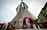Des bougies à l'effigie du pape François et de Padre Pio déposées au pied de la statue de Jean Paul II devant l'hôpital Gemelli où le pape François est hospitalisé, le 19 février 2025 à Rome