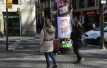 Des passants marchent devant des affiches électorales à Barcelone, le 19 décembre 2017