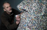 Rob Arnold à côté de sa sculpture "Une leçon d'histoire" composée de "nurdles", au Musée maritime national de Cornouailles, le 27 février 2023  à Falmouth, dans le sud-ouest de l'Angleterre