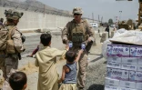 Une photographie publiée par l'armée américaine montre un militaire américain donnant de l'eau à des enfants pendant les opérations d'évacuations à l'aéroport international de Kaboul le 20 août 2021 