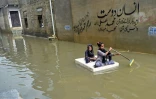 Radeau de fortune dans une rue de Karachi, dans le sud du Pakistan, inondée par les pluies de mousson, le 26 juillet 2022