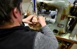 Une employée de Petitcollin fixe les cheveux à la tête d'une poupée dans l'atelier de fabrication, le 29 novembre 2019 à Etain, dans la Meuse